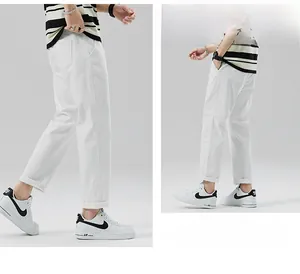 Dettaglio dei pantaloni casual bianchi da uomo con tessuto in twill di cotone minimalista