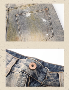 Detail of vintage blue denim jeans with rust wash effect and metal button closure