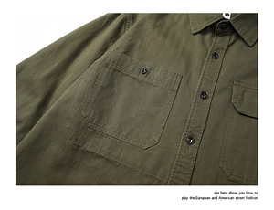 Détail d'une chemise de travail en coton vert olive avec col boutonné et poches surpiquées