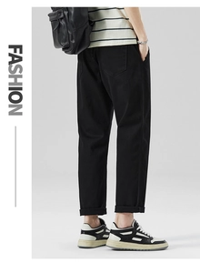 Dettaglio dei pantaloni casual neri da uomo, vestibilità dritta con risvolto sul retro