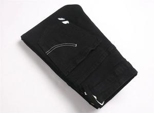 Detail of back pocket with white double-arc embroidery on black slim distressed jeans