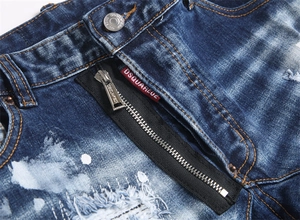 Detailed close-up of blue distressed jeans with metal zipper fly and branded button
