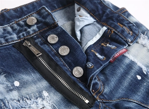 Detail of blue distressed denim jeans showing metal buttons and logo tag on the fly