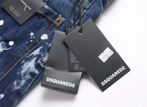 Detail of RIDER JEAN tag on blue distressed denim with white paint splatter effect
