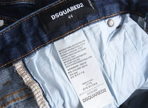 Detail view of the inner woven brand label and fabric care tag on men's slim jeans