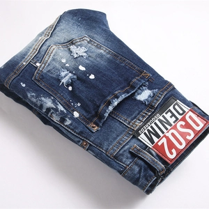 Men's blue distressed denim jeans with paint splatter and vintage washed finish
