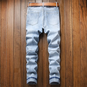 Jean denim bleu clair pour hommes avec ceinture marron sur un fond en bois rustique