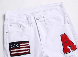 Detailed view of white jeans featuring red chenille embroidery and US flag patch