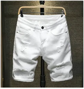 Détail d'un short en jean blanc avec déchirures usées et style classique à cinq poches