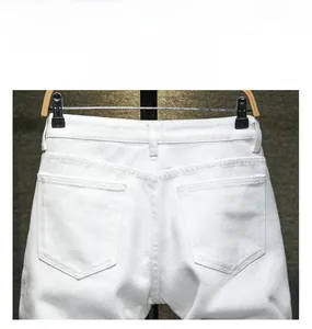 Détails des poches arrière et passants de ceinture sur short en jean blanc pour homme