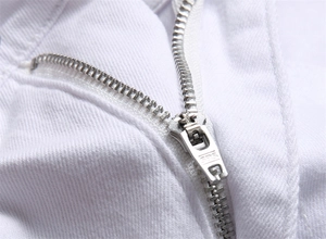 Macro shot of high-quality SBS metal zipper on white denim jeans with precise stitching