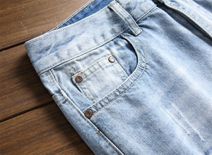 Détail de la taille en denim bleu clair, poche et rivets sur jean droit pour homme