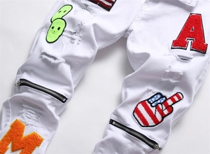Close-up of white distressed denim with vibrant chenille patches and street style embroidery