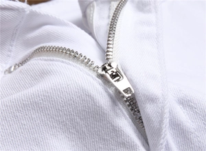 Detailed close-up of high-quality white cotton denim fabric with a durable metal zipper