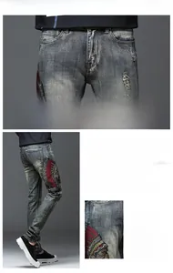 Détail d'un jean slim bleu avec broderie de chef indien et effets d'usure naturels