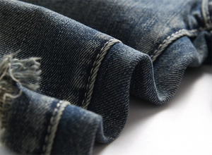 Detaillierte Makroansicht von Denim-Stoff mit Distressed-Effekt und Doppelnaht-Details