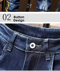 Detailed view of dark blue denim jeans featuring a silver button with fashion engraving