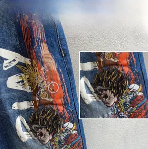 Detaillierte Nahaufnahme der aufwendigen Sun Wukong Stickerei auf dunkelblauer Denim-Jeans