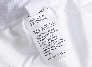 Detail view of clothing care label showing fabric composition 98% cotton and 2% elastane