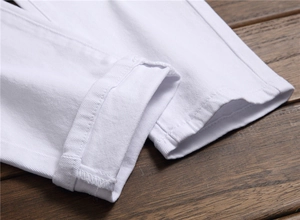 Close-up of white cotton denim pant leg showing high-quality stitched hem details