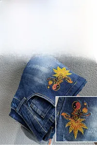 Makroaufnahme von Streetstyle-Jeans mit Stickereien, Ahornblatt und Yin-Yang-Mustern