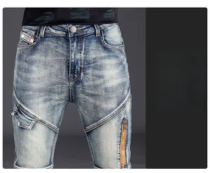Macro shot of light blue slim fit jeans featuring orange metal zipper and panel stitching