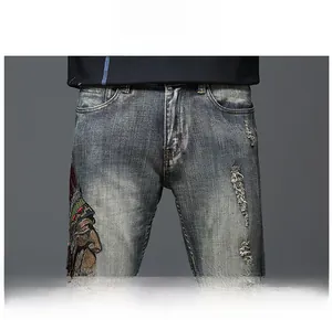 Détail du jean bleu avec broderie amérindienne et texture vintage usée à la taille