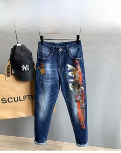 Detailansicht der schmal geschnittenen blauen Jeans mit Graffiti- und Anime-Charakter-Print