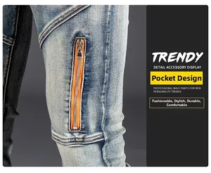 Detail of light blue washed slim fit jeans with orange metal zipper pockets and distressed finish