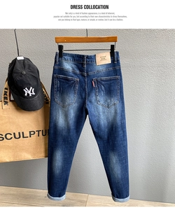 Detail einer dunkelblauen Jeans mit bestickten Gesäßtaschen und Lederetikett am Bund