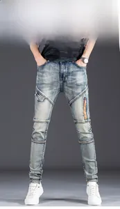 Detail of light blue washed slim fit jeans featuring biker zippers and utility pockets