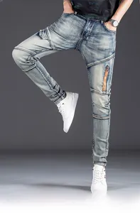 Detail of slim-fit men's jeans with vintage wash and orange metal zipper on thigh