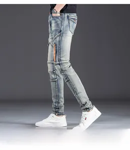 Detail of men's slim fit jeans showing orange zipper pocket and light blue washed fabric