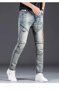 Detail of light blue slim fit denim pants with decorative brass zippers and washed texture