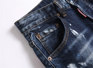 Détails de jeans denim bleu foncé délavé avec taches de peinture et étiquette rouge iconique