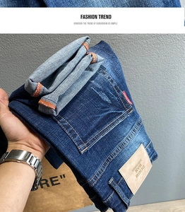 Detail der dunkelblauen Jeans mit Kontrastnähten, Lederpatch und Waschungseffekten
