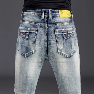 Men's slim fit straight jeans in light blue wash with vintage faded details and leather patch