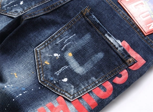 Gros plan sur le jean bleu slim avec délavage usé et accents de taches de peinture