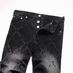 Men's punk style black straight denim jeans featuring cross patches with beaded studs