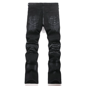 Detail of washed black motorcycle jeans showing pleated knees and distressed texture