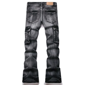 Detail view of washed black slim fit flared jeans with cargo pockets and distressed texture