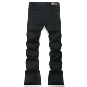 Vue arrière du jean noir empilé avec ourlets effilochés et écusson en cuir