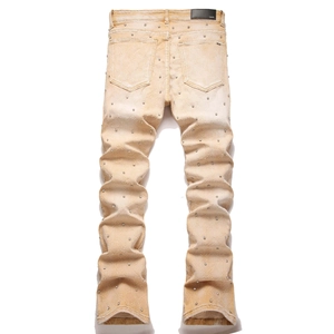 Detailaufnahme des schwarzen Lederlabels und der silbernen Nieten auf der Khaki-Jeans