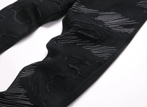 Gros plan détaillé sur denim noir avec broderie zigzag blanche et déchirures de style
