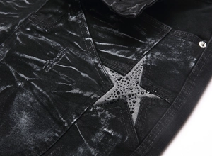 Macro view of black washed denim jeans with a rhinestone star patch and twill texture