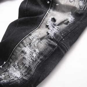 Distressed black-grey slim fit jeans with rip repair and white paint splatter details