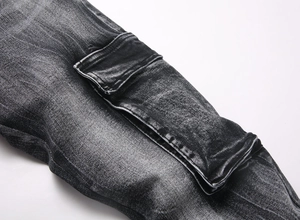Detailed macro view of vintage washed black denim cargo pants with large utility pockets