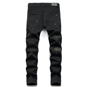 Rear view of black stretch slim jeans with white paint splatters and yellow wave embroidery