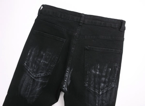 Detail of street art graffiti hand print on the back pocket of black denim jeans