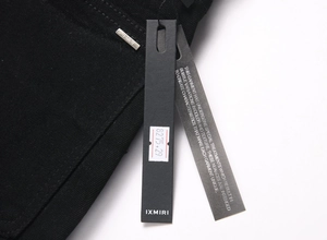 Gros plan détaillé du denim noir avec logo de marque argenté et étiquettes produits